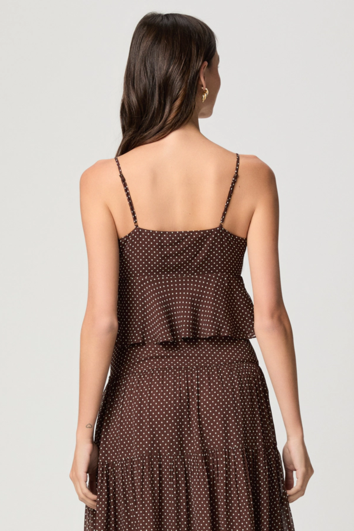 Model wearing a mahogany and ecru color-block camisole with adjustable straps.