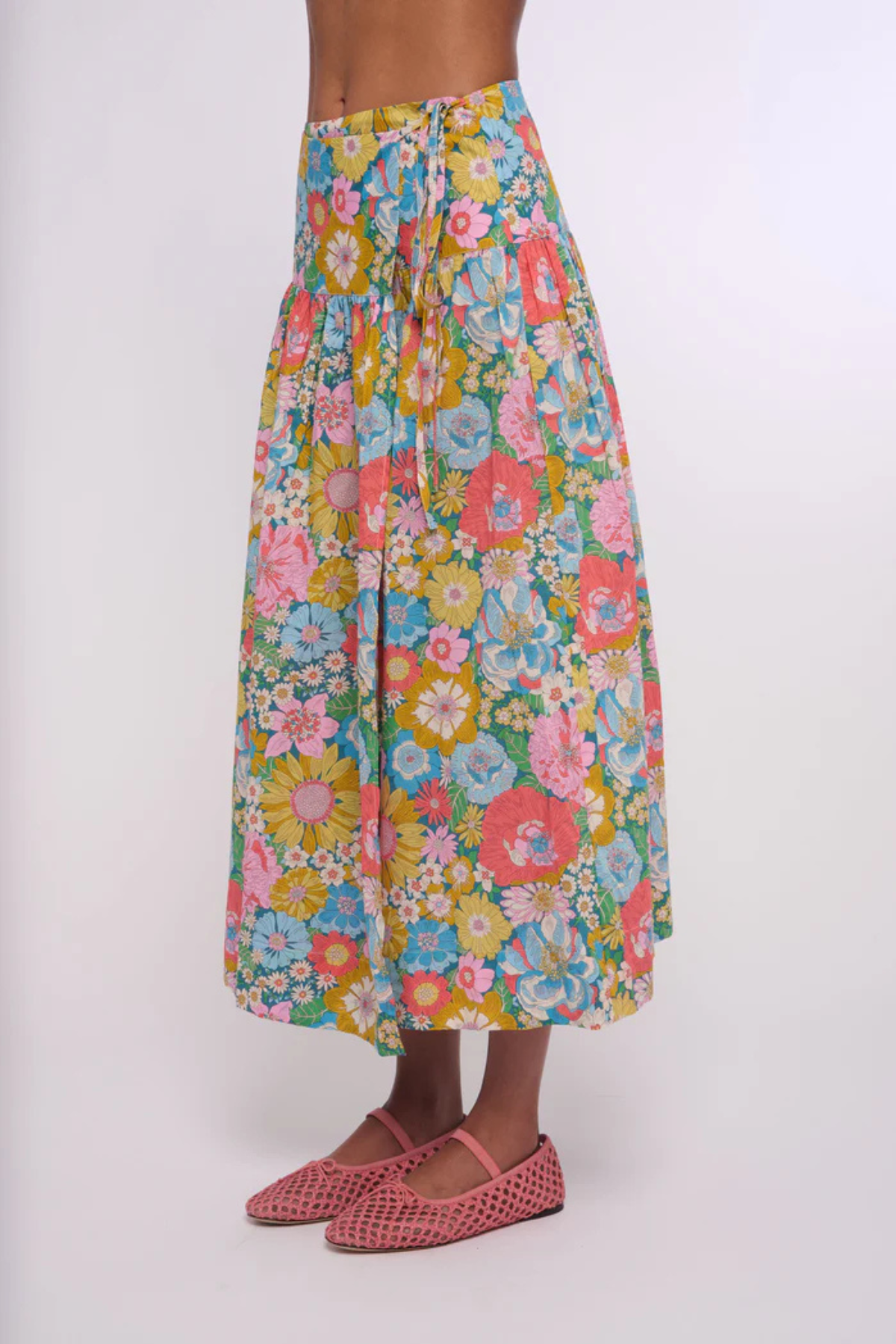 Person wearing a colorful floral skirt on a white background