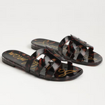 Pair of tortoiseshell sandals with gold text on a light gray background