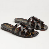 Pair of tortoiseshell sandals with gold text on a light gray background