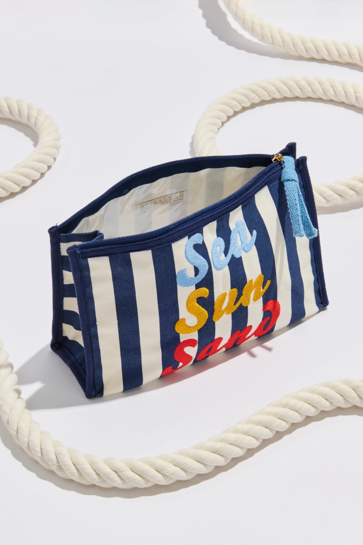 Striped pouch with 'Sea Sun Sand' text on a white background