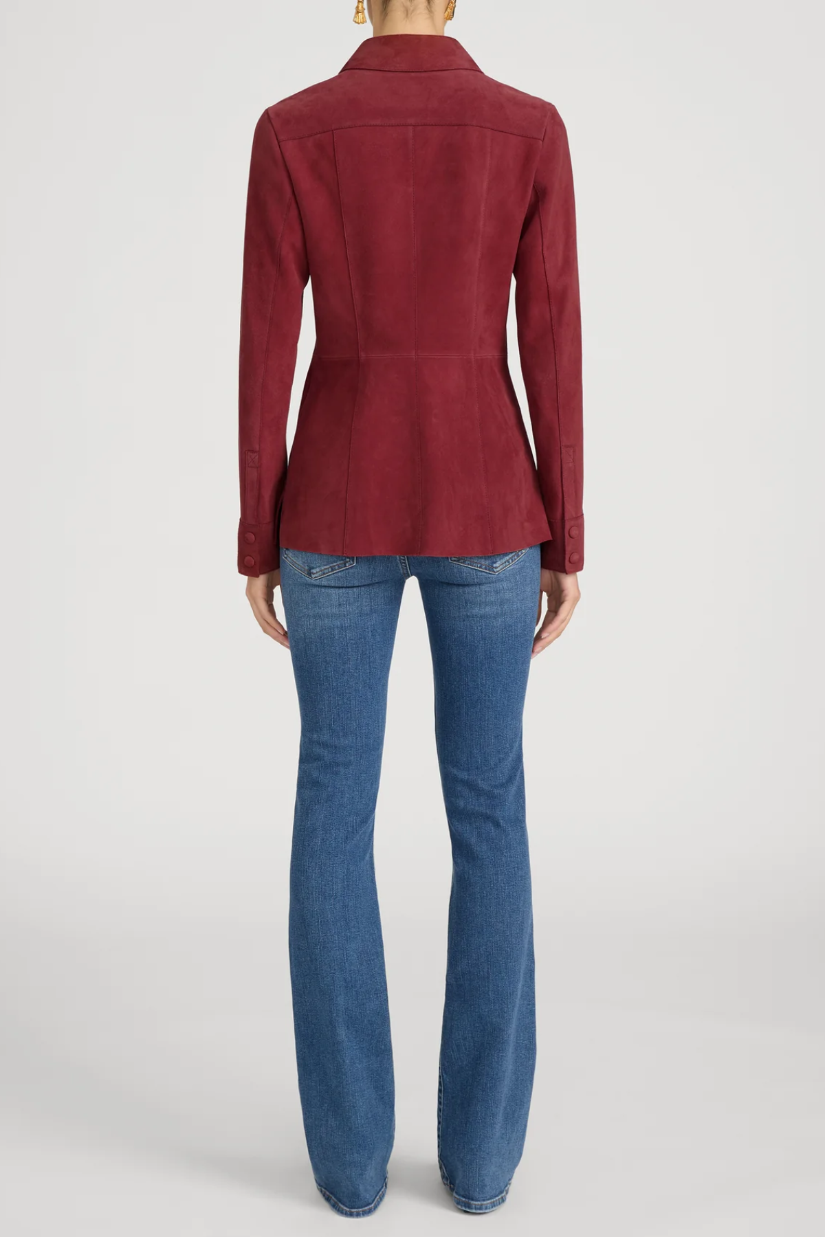 Person wearing a red jacket and blue jeans on a white background