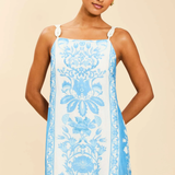 Woman wearing a blue floral dress on a beige background