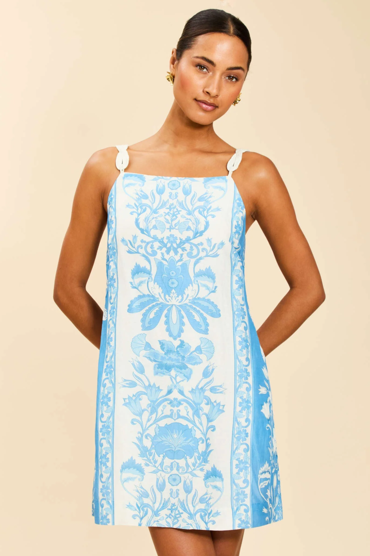 Woman wearing a blue floral dress on a beige background