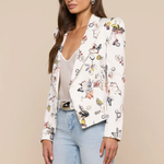 Woman wearing a white blazer with colorful butterfly pattern on a beige background