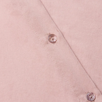 Close-up of a pink fabric with buttons on a matching pink background