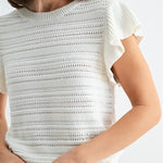 White textured top worn by a person on a white background