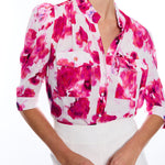 blurred floral short sleeve button down blouse on woman with white background 