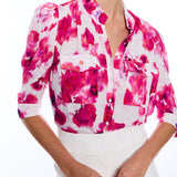 blurred floral short sleeve button down blouse on woman with white background 