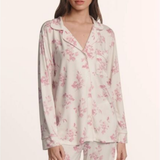 Woman wearing a floral pajama set on a white background