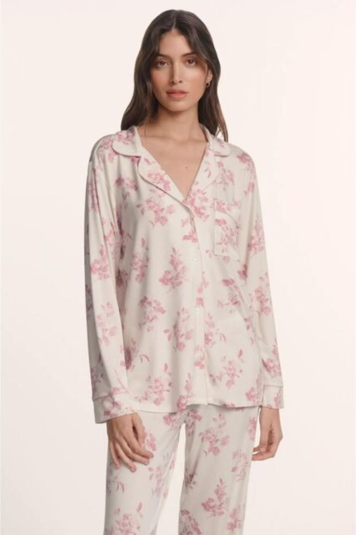Woman wearing a floral pajama set on a white background