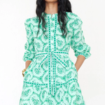 woman in printed green mini dress on white background 