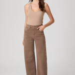 Woman wearing a beige tank top and wide-leg pants on a white background