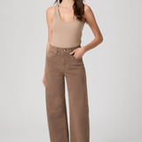 Woman wearing a beige tank top and wide-leg pants on a white background