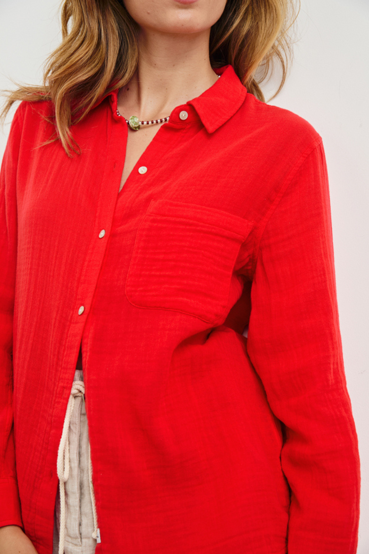 Red button-up shirt worn by a person on a white background