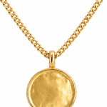 A gold-toned necklace featuring a textured, circular disc pendant suspended from a matching curb chain, set against a plain white background.