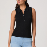 Woman wearing a black sleeveless ribbed polo shirt and light blue jeans on a plain background