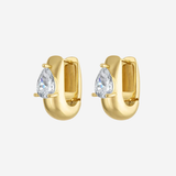 A pair of gold huggie hoop earrings, each featuring a pear-cut clear gemstone in a prong setting, shown against a light gray background.