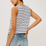 Woman wearing a striped tank top and jeans on a plain background