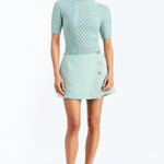 Woman wearing a soft mint cable knit sweater with a smooth, lightweight knit and polished neckline