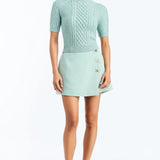 Woman wearing a soft mint cable knit sweater with a smooth, lightweight knit and polished neckline