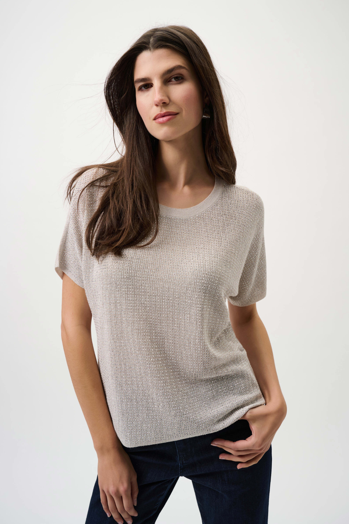 Woman wearing a beige short-sleeve top against a white background