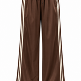 Women's brown pants featuring contrasting side stripes and a relaxed full-length silhouette.