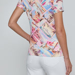 Person wearing a colorful patterned shirt with white pants on a plain background