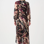 Woman wearing a long, patterned dress on a white background