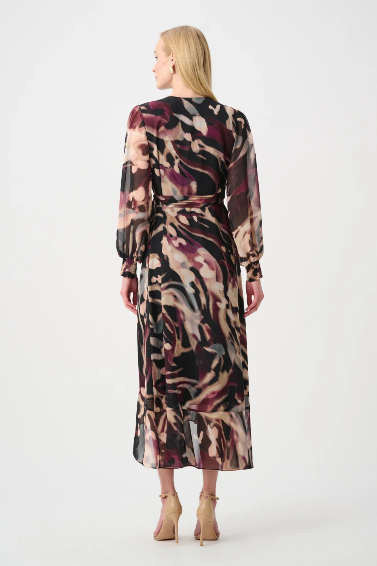 Woman wearing a long, patterned dress on a white background