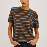 Woman wearing a brown and blue striped t-shirt against a plain background