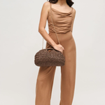 Woman wearing a brown outfit with a matching handbag on a white background