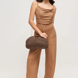 Woman wearing a brown outfit with a matching handbag on a white background