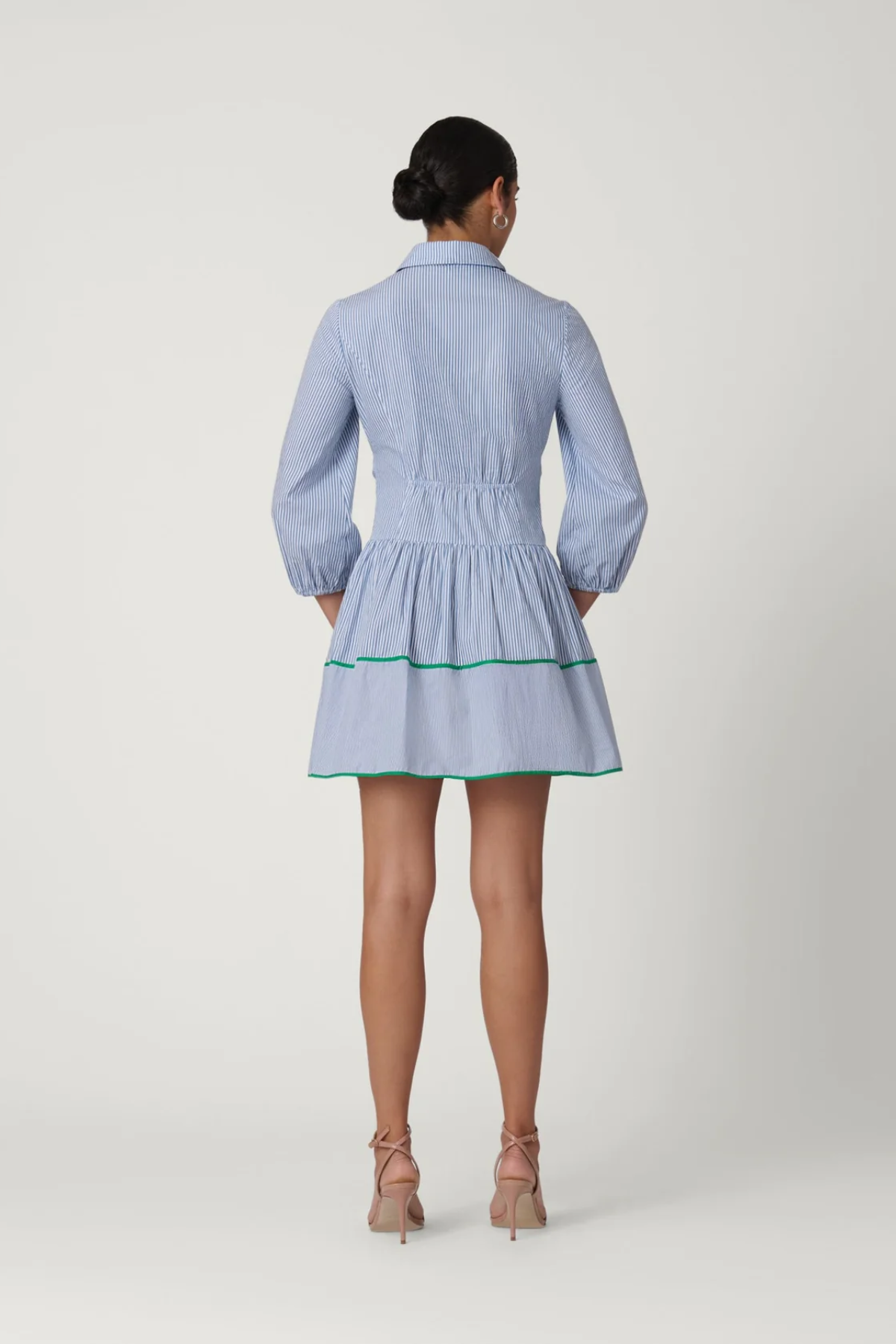 Woman wearing a light blue dress with a white background