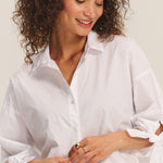 Woman wearing a white shirt against a plain background