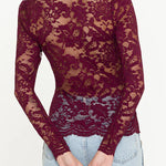 Maroon lace long-sleeve top worn by a person, with a focus on the garment.