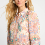 Woman wearing a patterned shirt with a plain background