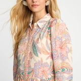 Woman wearing a patterned shirt with a plain background
