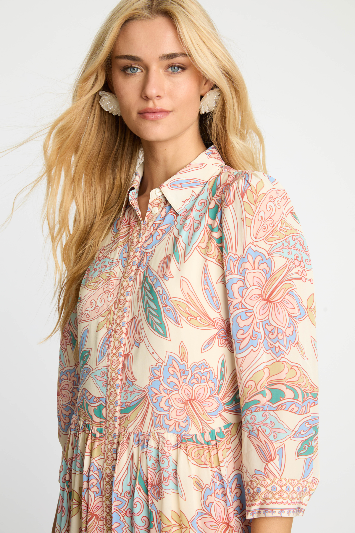Woman wearing a patterned shirt with a plain background