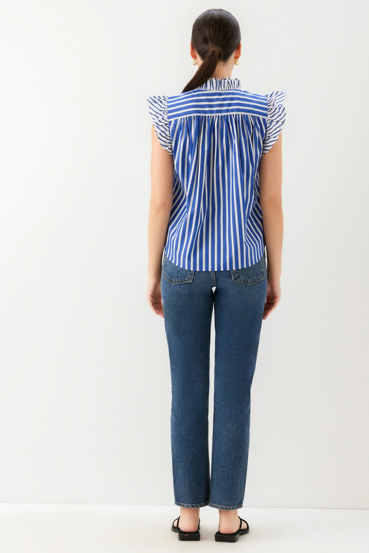 back of woman in jeans and stripe ruffle top