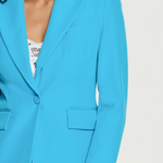 Blue blazer worn by a person on a white background