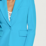 Blue blazer worn by a person on a white background