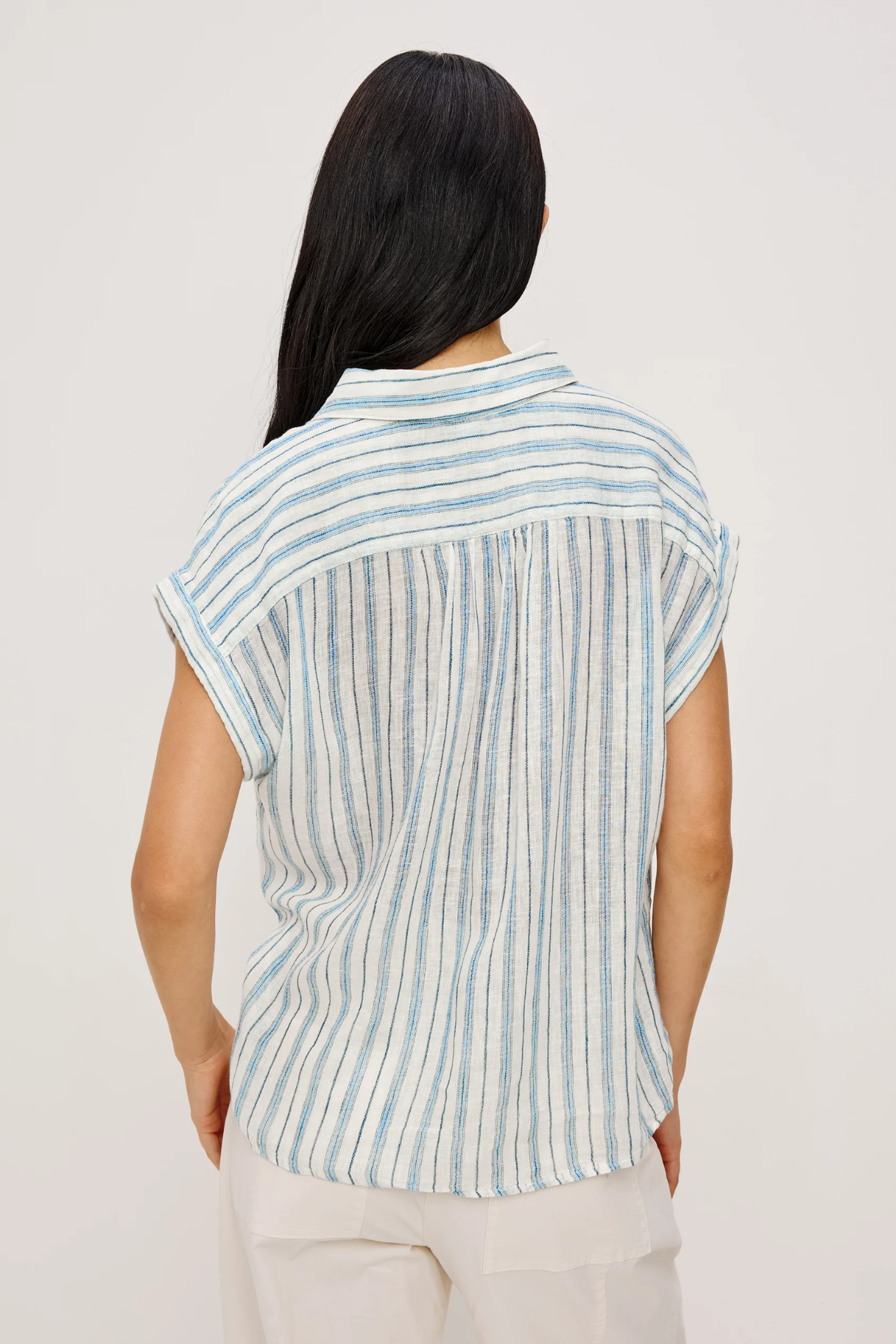 Woman wearing a striped shirt with a plain background