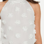 White floral halter top worn by a person on a white background
