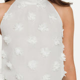White floral halter top worn by a person on a white background