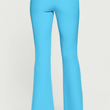 Turquoise pants worn by a person on a white background