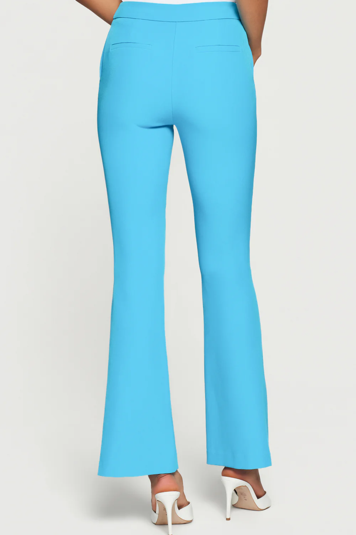 Turquoise pants worn by a person on a white background