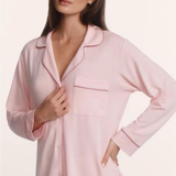 Woman wearing a pink pajama set against a light pink background