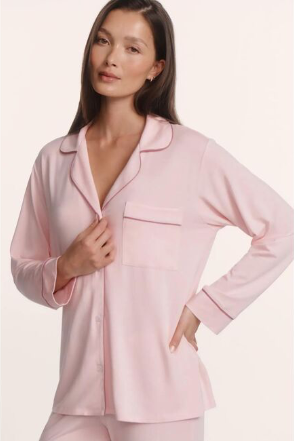Woman wearing a pink pajama set against a light pink background