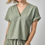 Woman wearing a green outfit with a plain background